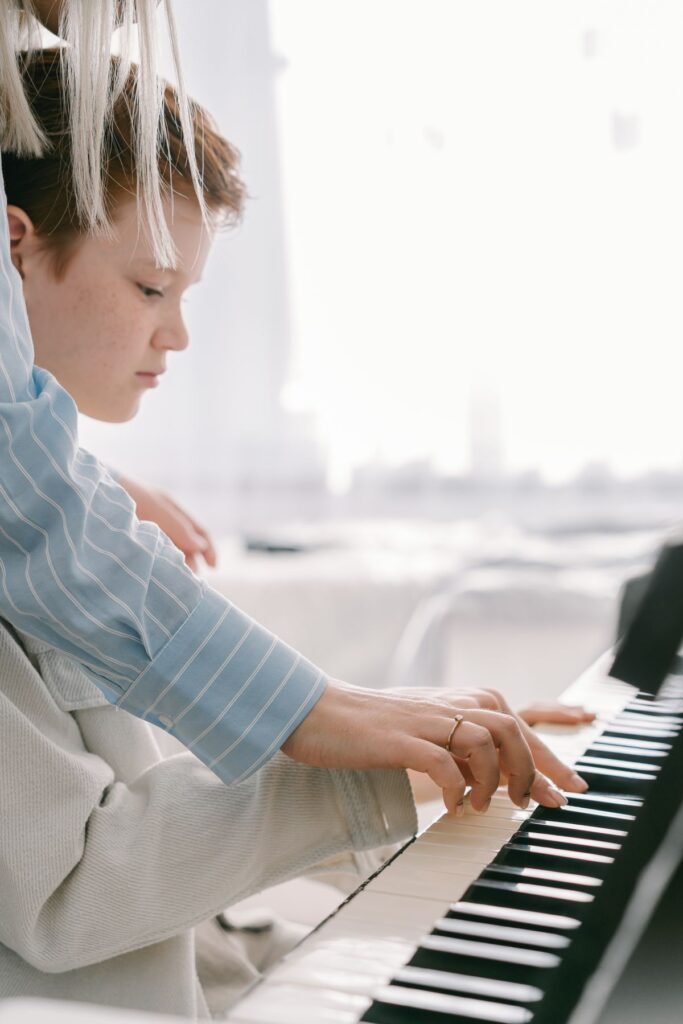 Trẻ học piano với giáo viên hướng dẫn