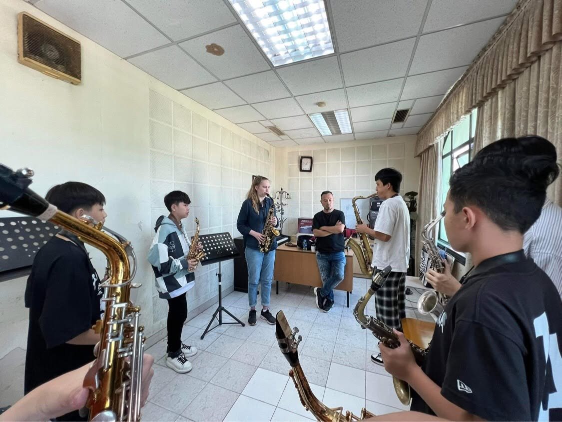 Portrait of instructor Lê Duy Mạnh holding a saxophone in a teaching space